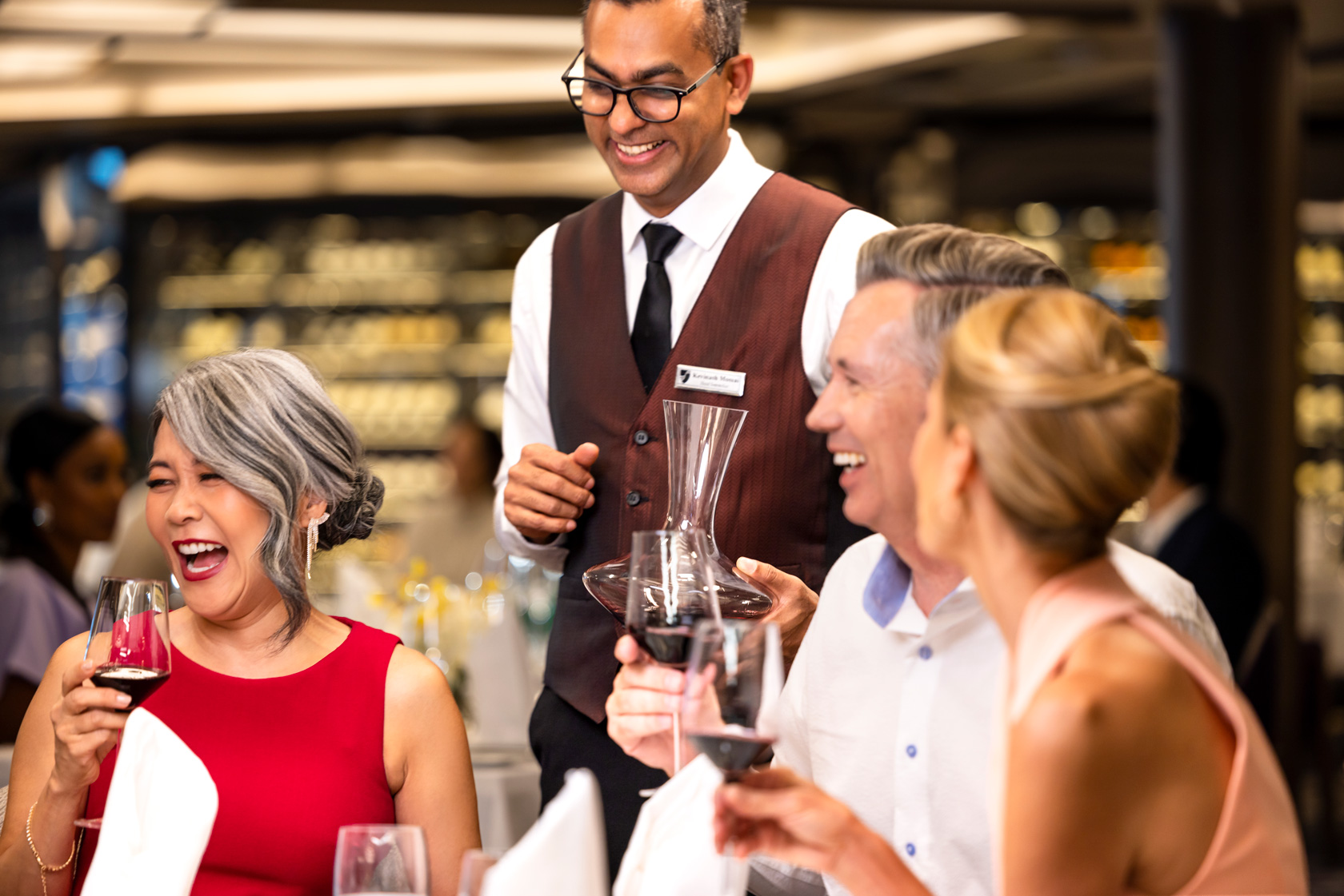 Seabourn passengers toast their glasses of wine over an elegant meal.