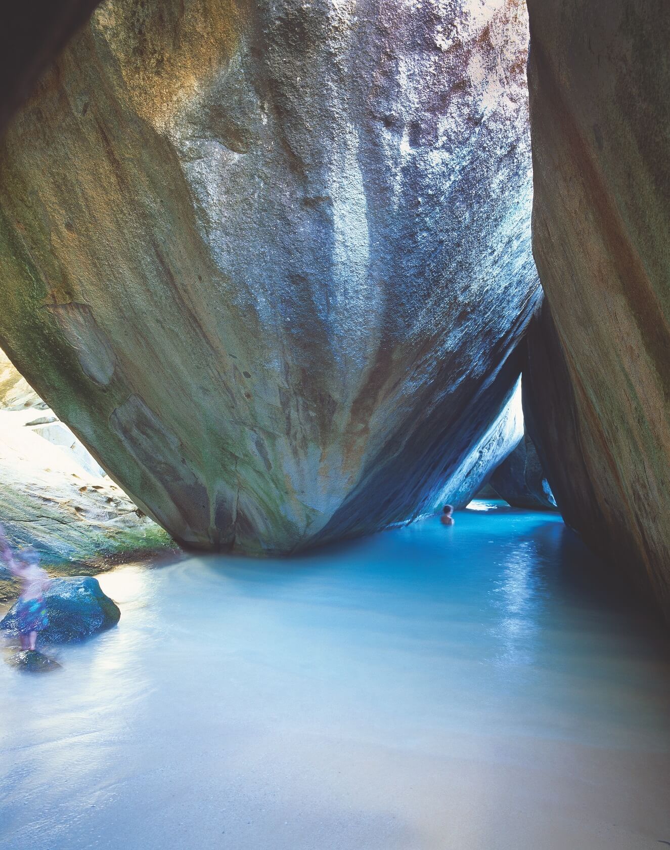 A swimming cave with the sunning shining through the rocks