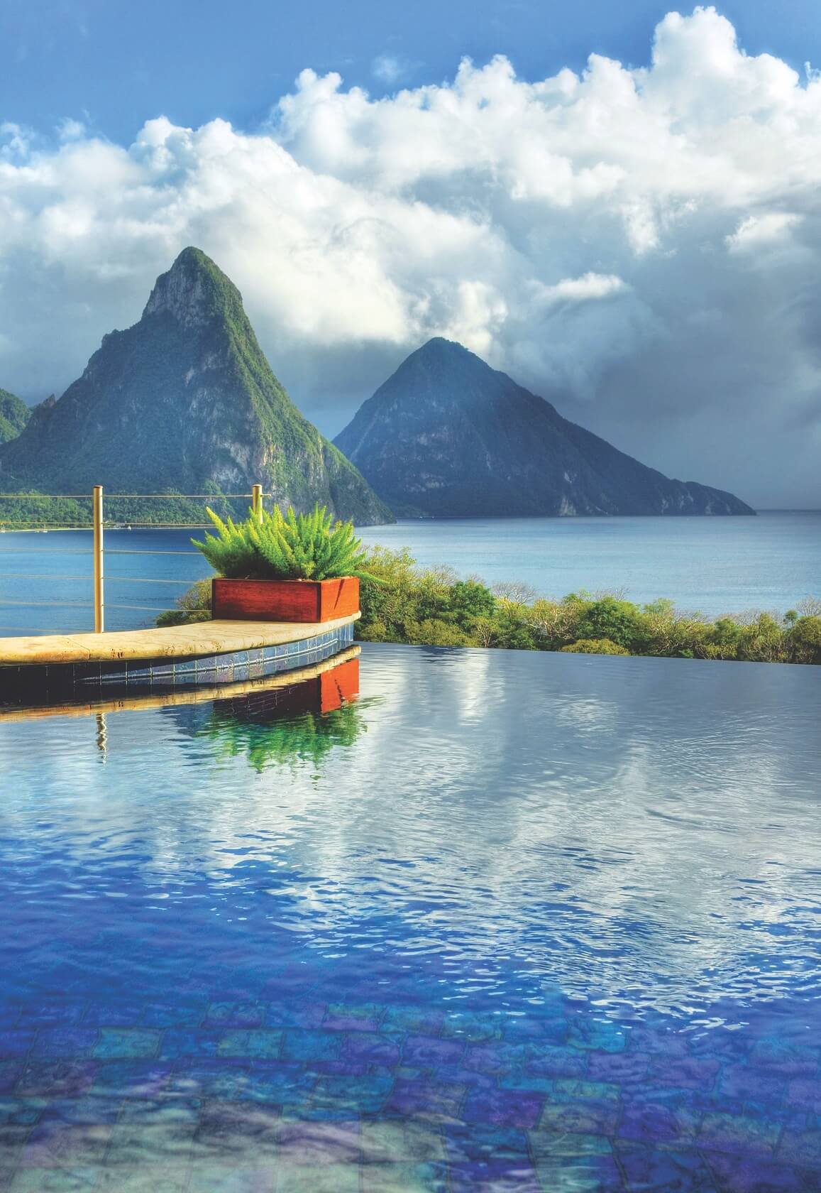 Two volcanos by the blue sea with clouds in the sky 