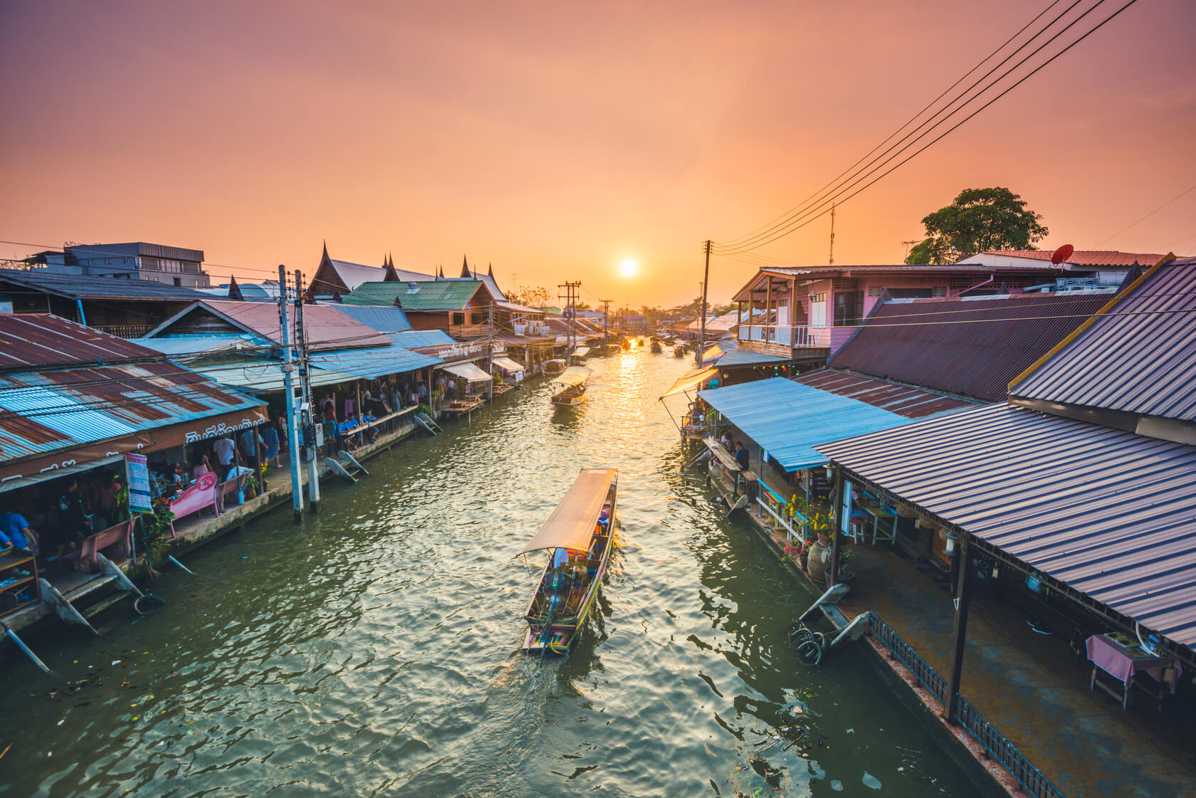 A boat rows down a canal in Bangkok, Thailand