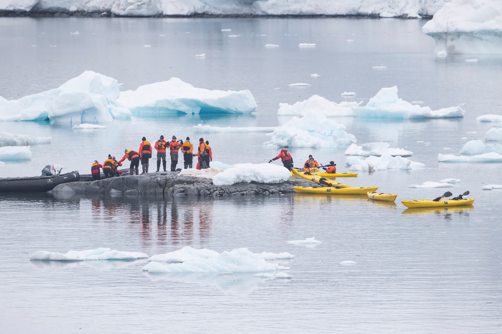 Seabourn passengers find footing and move from their inflatable boat and into kayaks.