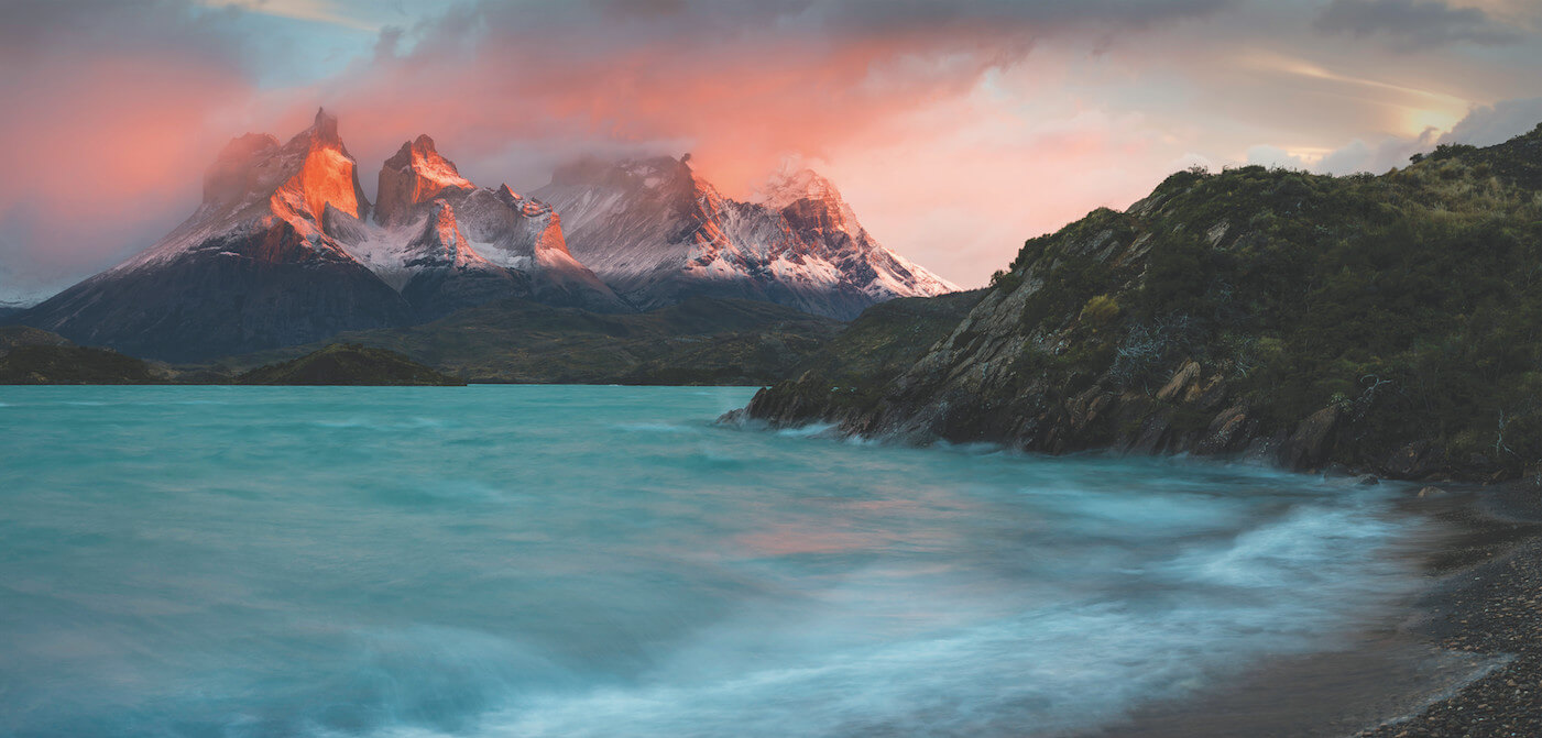 A landscape at sunset overlooking the coast line and mountains in Patagonia in the background