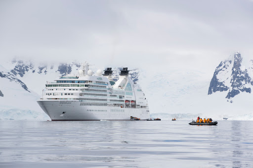 An inflatable boat approaches the Seabourn ship after an excursion amongst ice cliffs.