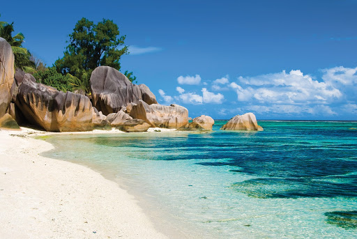Offshore view of blue skies, turquoise water and full of fluffy white sand.